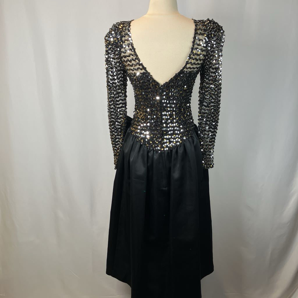 Black dress with silver sequin embellishments on a mannequin against a plain background