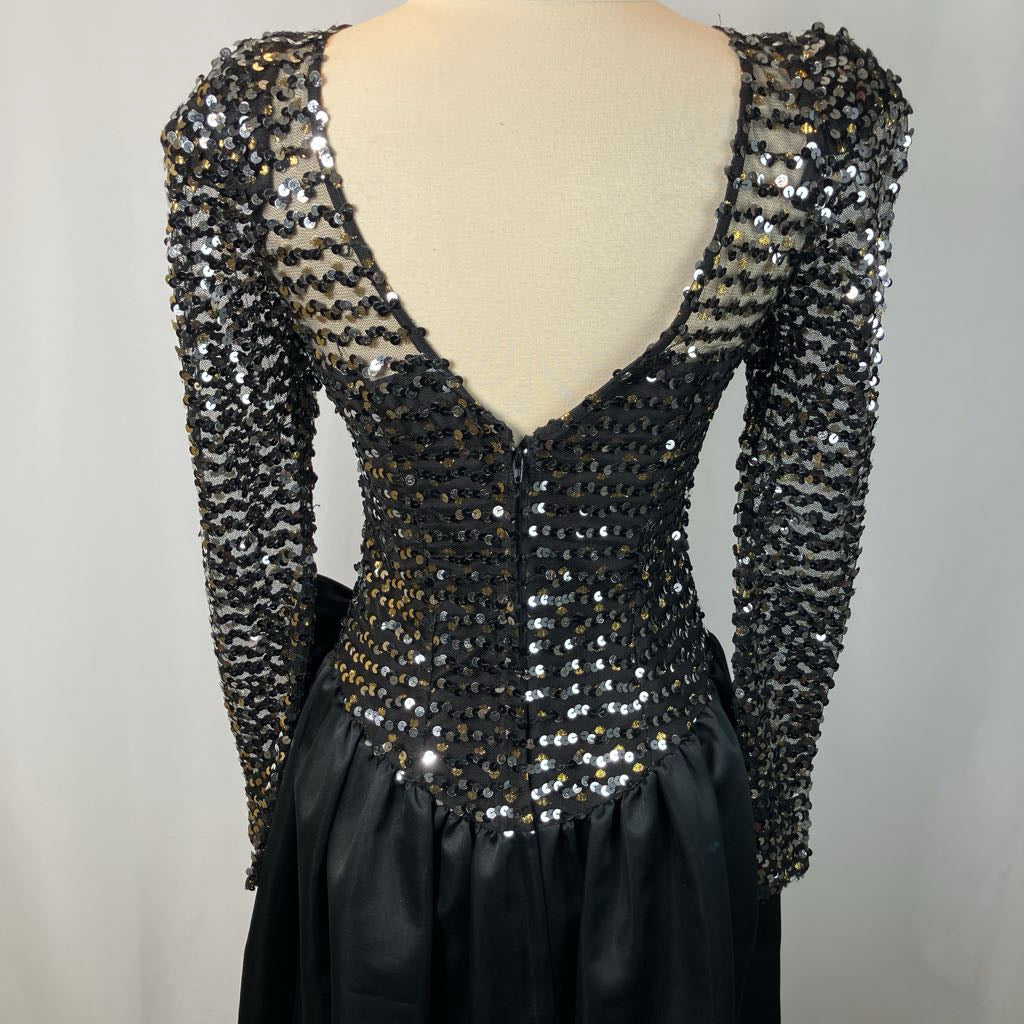 Black sequin dress on a mannequin with a plain background