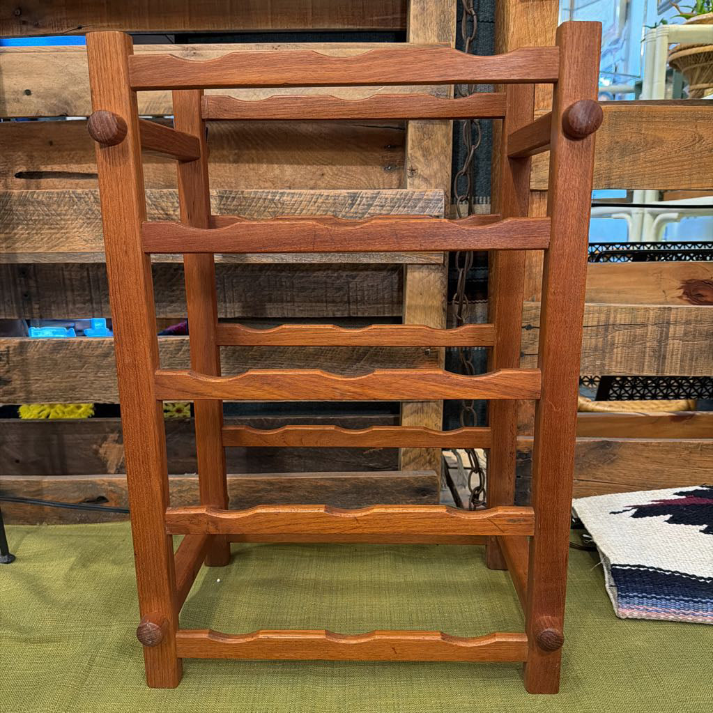 Wooden ladder shelf against a rustic wooden wall.