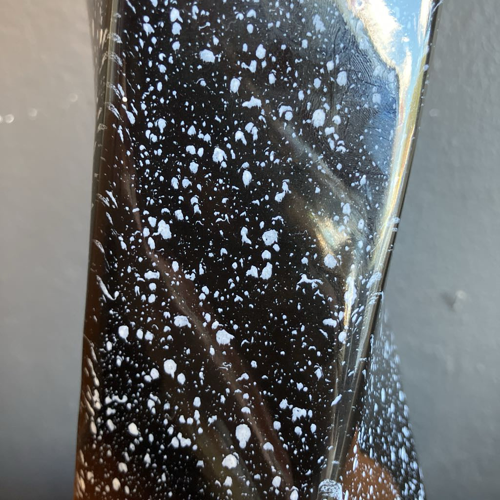 Close-up of a glass with white specks on a neutral background