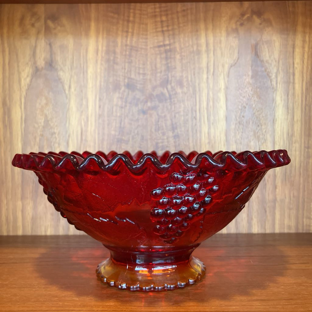 Red glass bowl with textured surface on a wooden surface and background