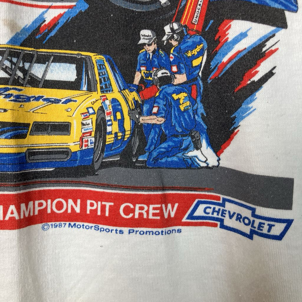 Vintage t-shirt with a graphic of a race car and pit crew, featuring Chevrolet branding.