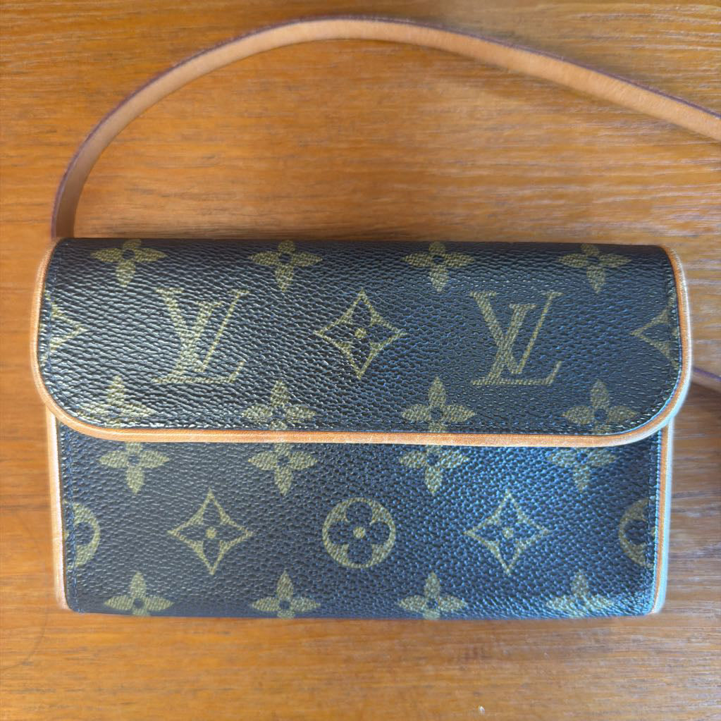 Designer handbag with monogram pattern on a wooden surface