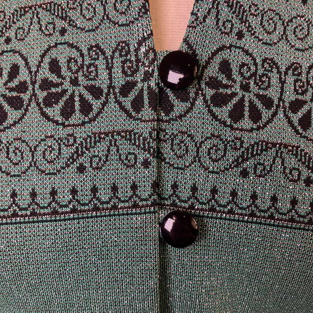 Close-up of a green fabric with black pattern and buttons