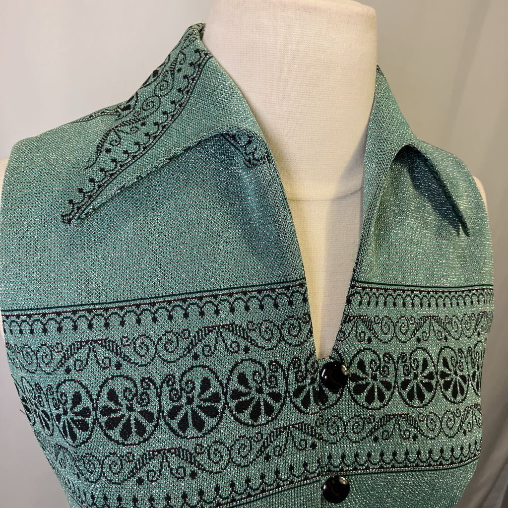 Teal vest with black pattern on a mannequin against a plain background