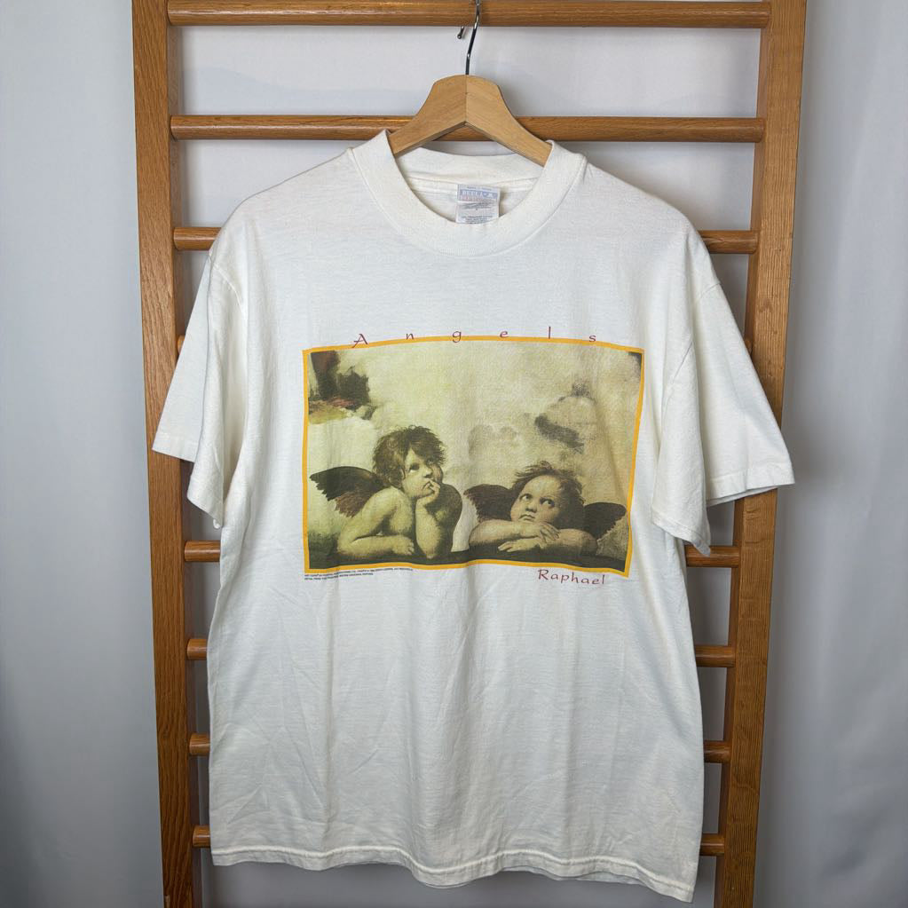 White t-shirt with angel graphic on a wooden rack