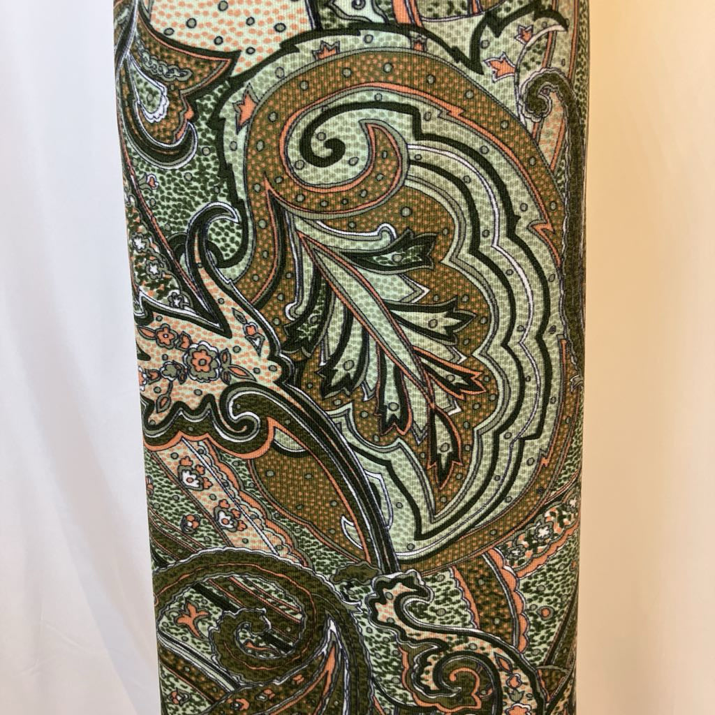 Close-up of a patterned fabric with intricate designs on a beige background