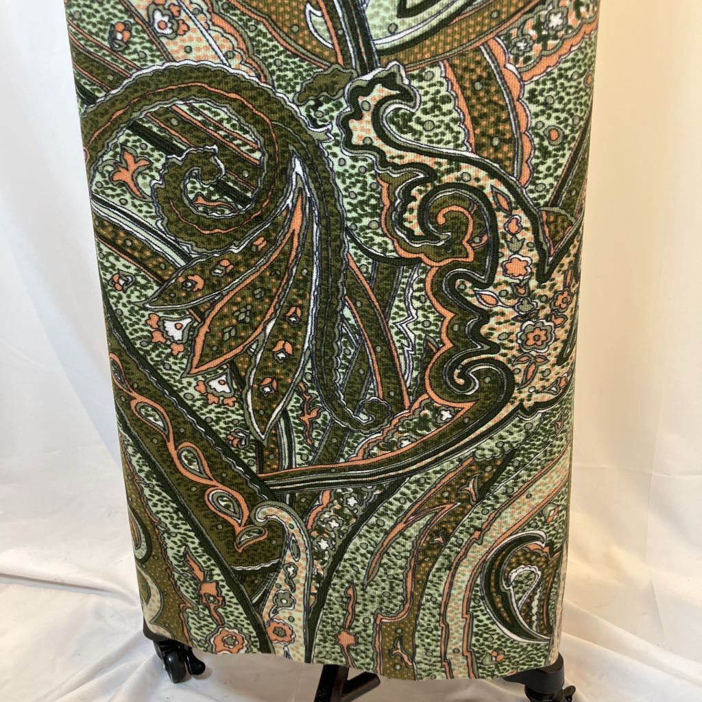 Green patterned fabric on a mannequin against a white background