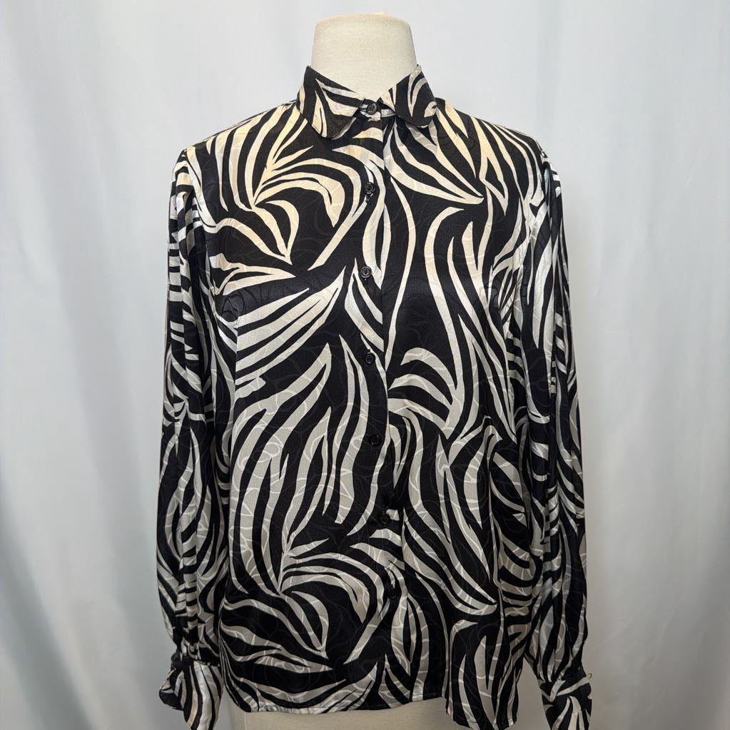 Black and white zebra patterned blouse on a mannequin against a plain background