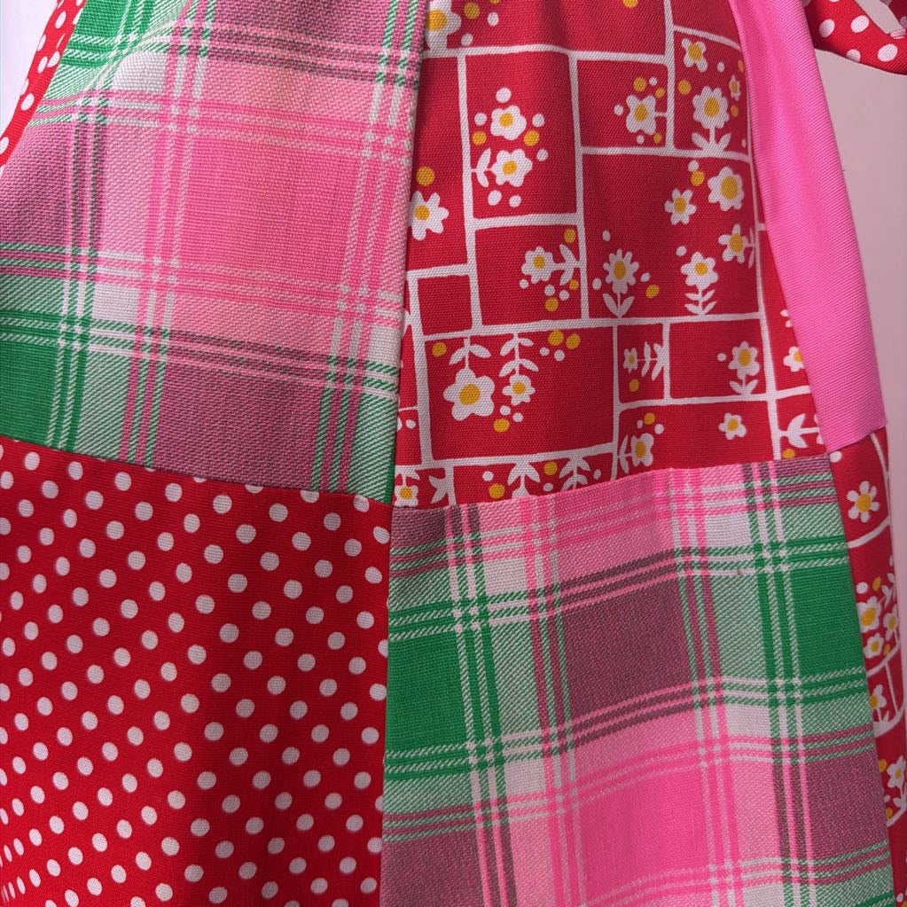 Close-up of fabric with plaid, polka dot, and floral patterns.