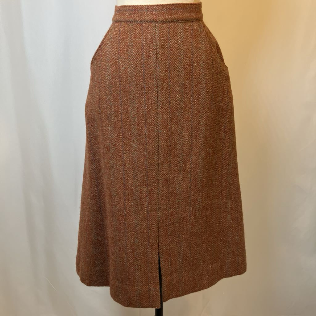 Brown tweed skirt on a mannequin against a plain background
