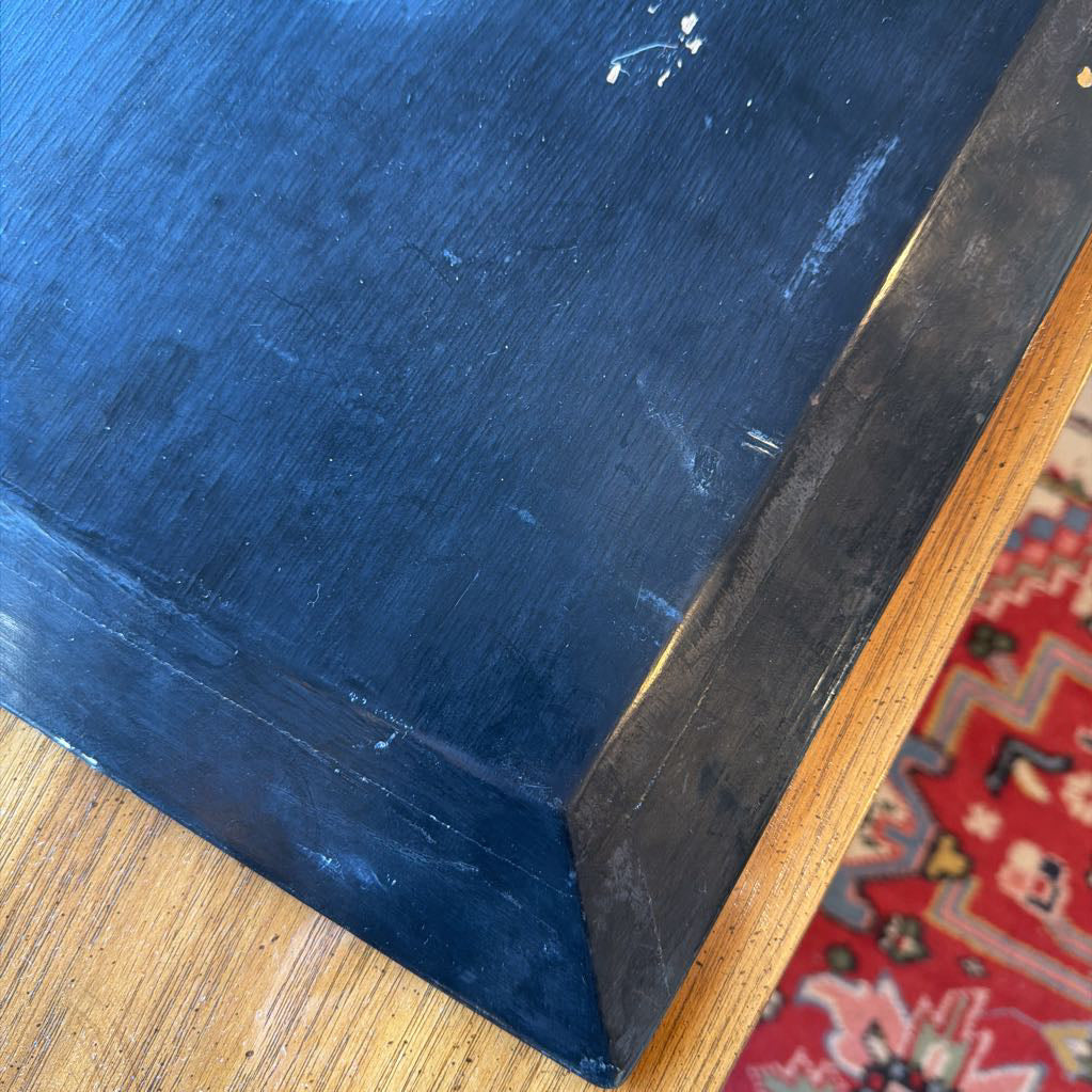 Close-up of a blue surface with a wooden frame and red patterned rug underneath