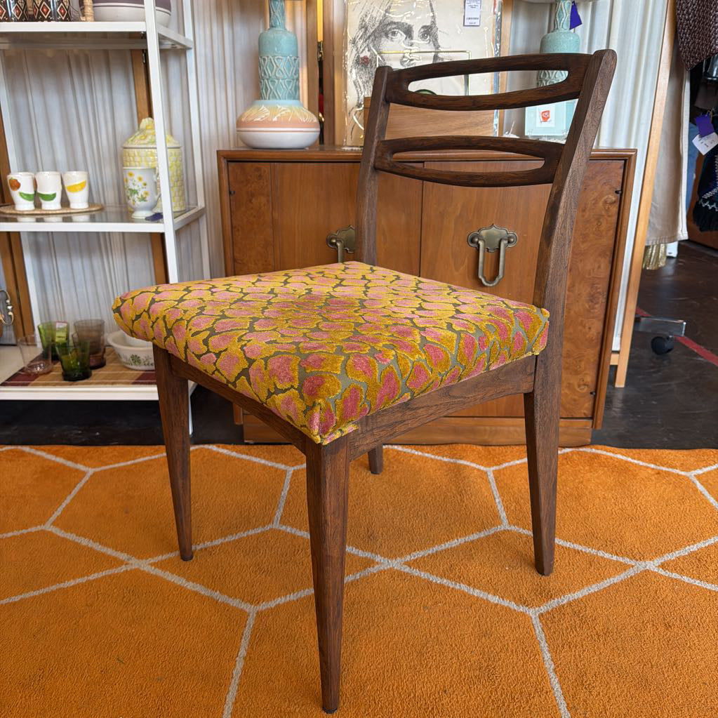 Wooden chair with a patterned cushion on an orange geometric rug