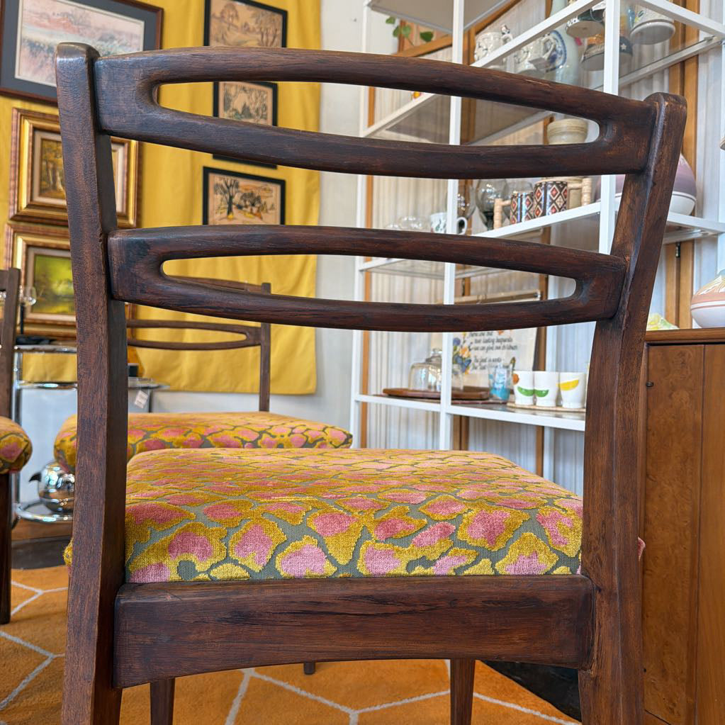Wooden chair with floral cushion in a room with yellow walls and decorative items.
