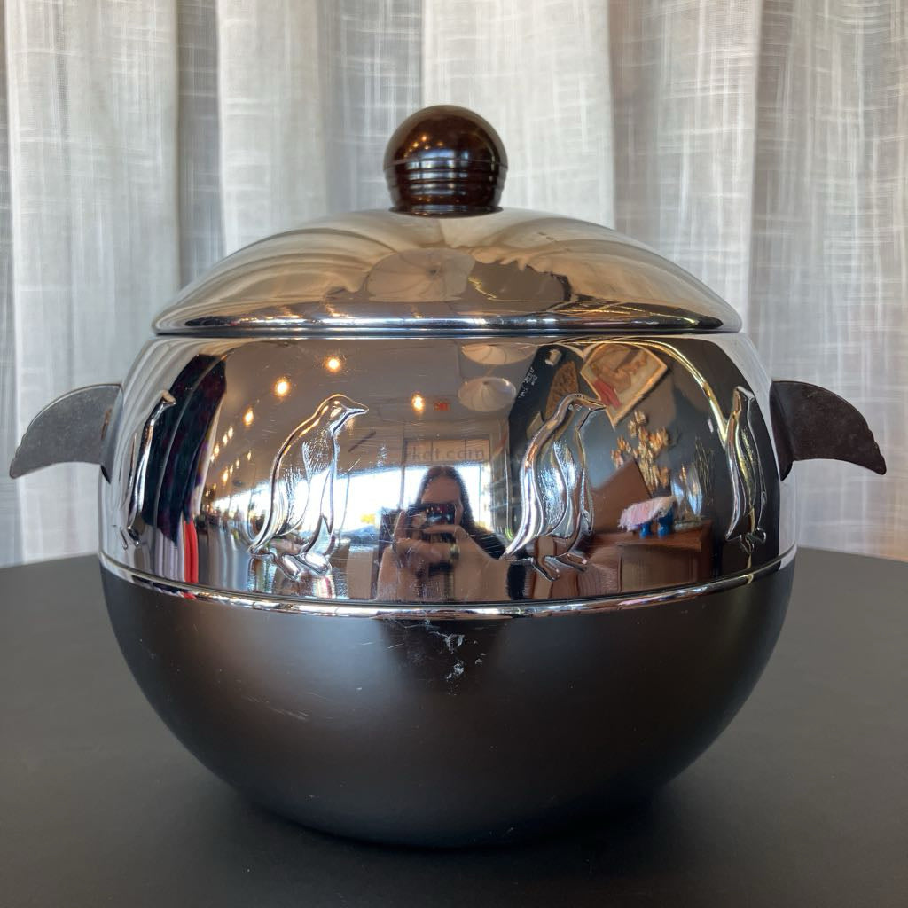 Silver ice bucket with handles and lid on a dark surface