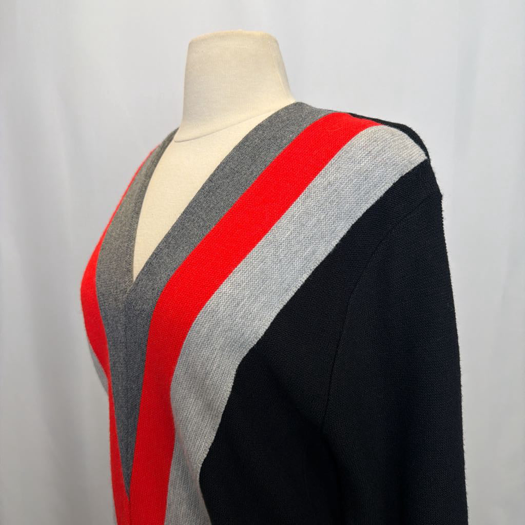 Mannequin wearing a sweater with black, red, and gray color pattern on a plain background