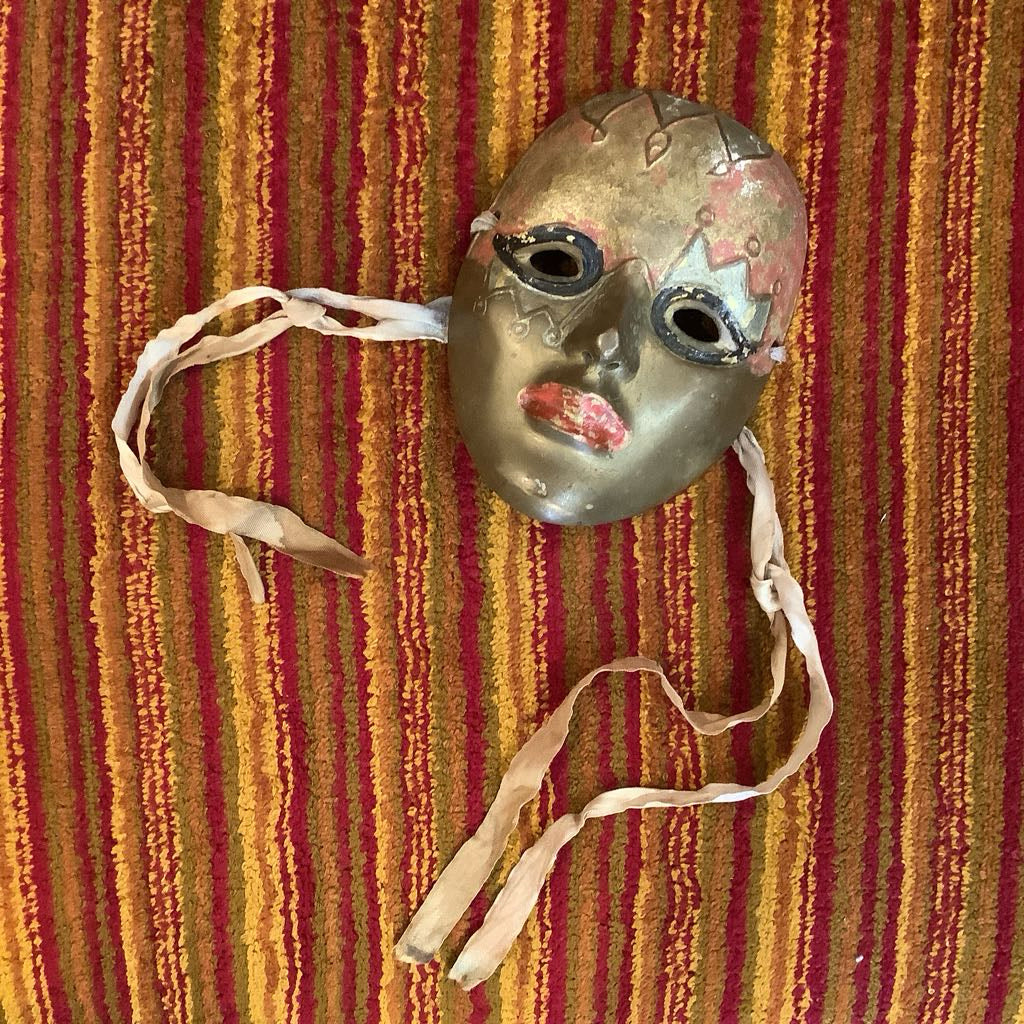 Vintage mask with ribbons on a striped red and orange background