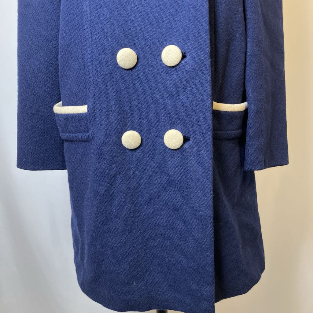 Blue coat with white buttons on a neutral background