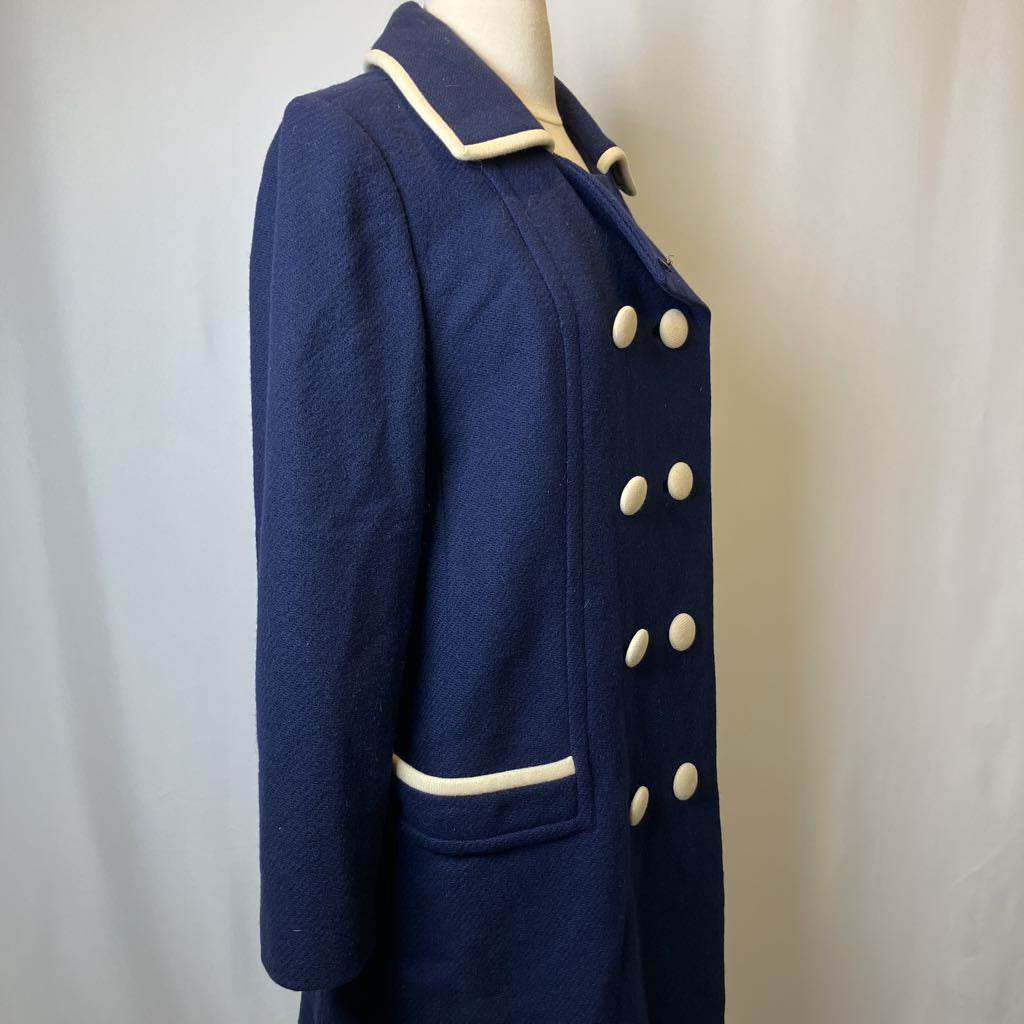 Navy blue coat with white buttons on a mannequin against a plain background