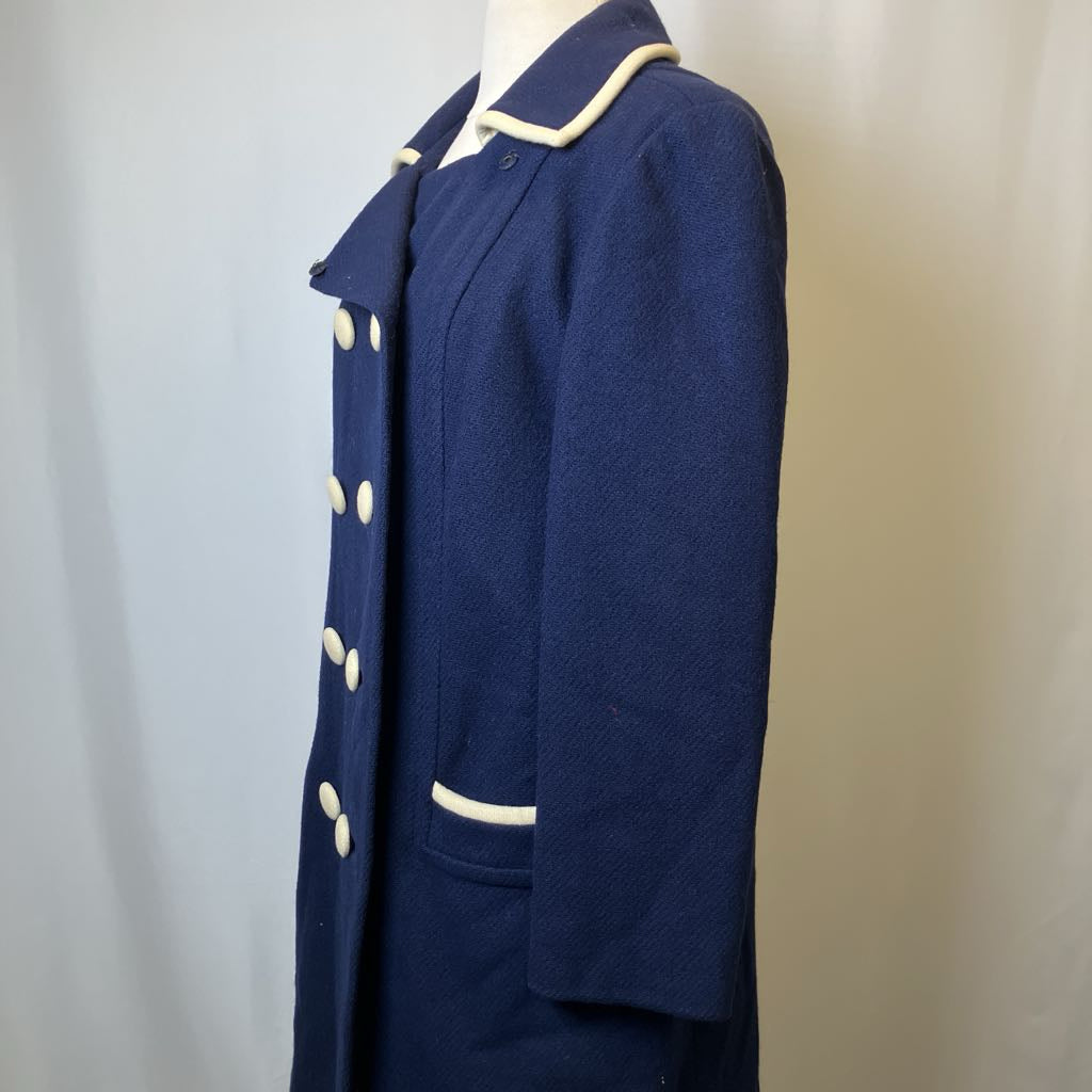 Navy blue coat with white buttons and trim on a mannequin against a plain background