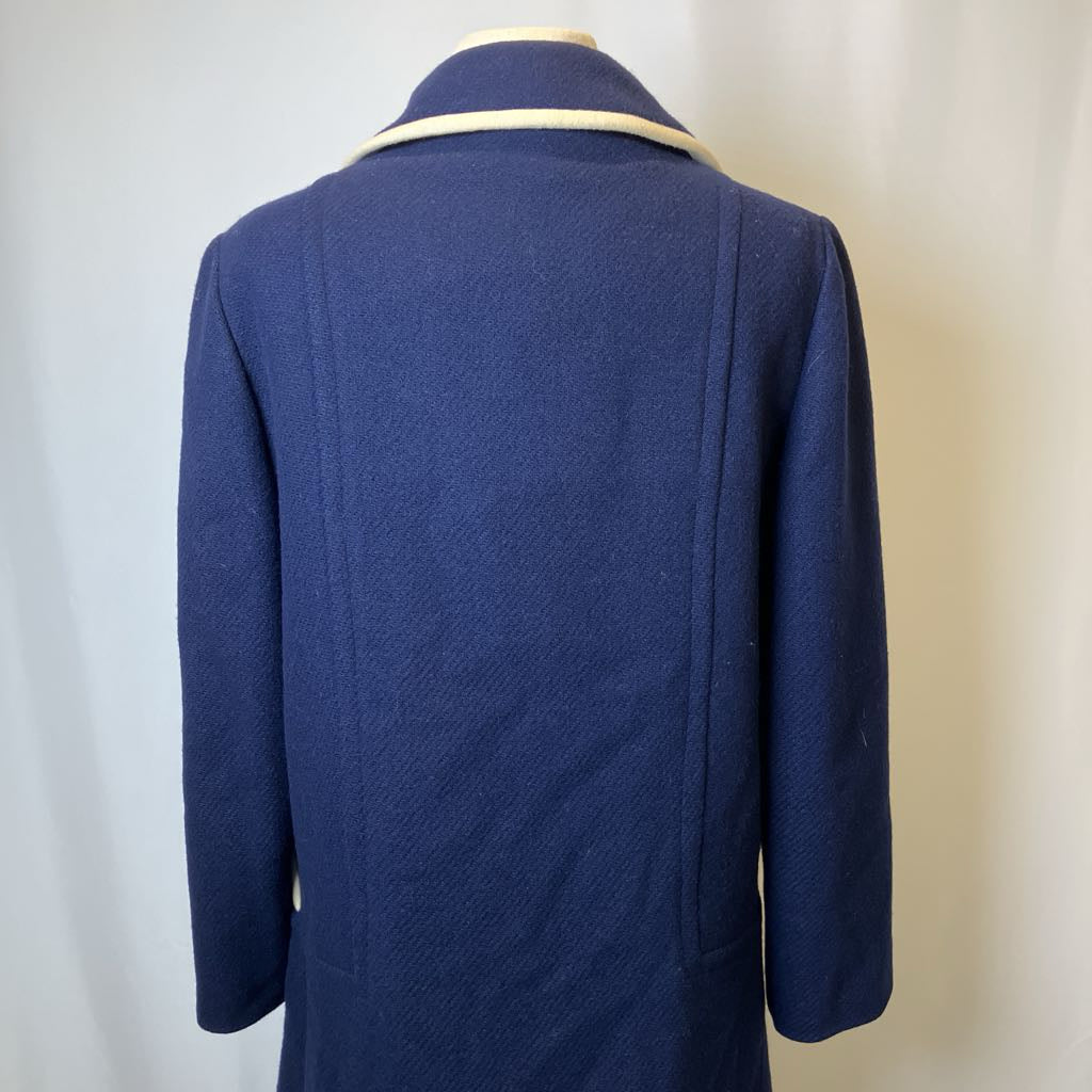 Blue coat on a mannequin against a plain background