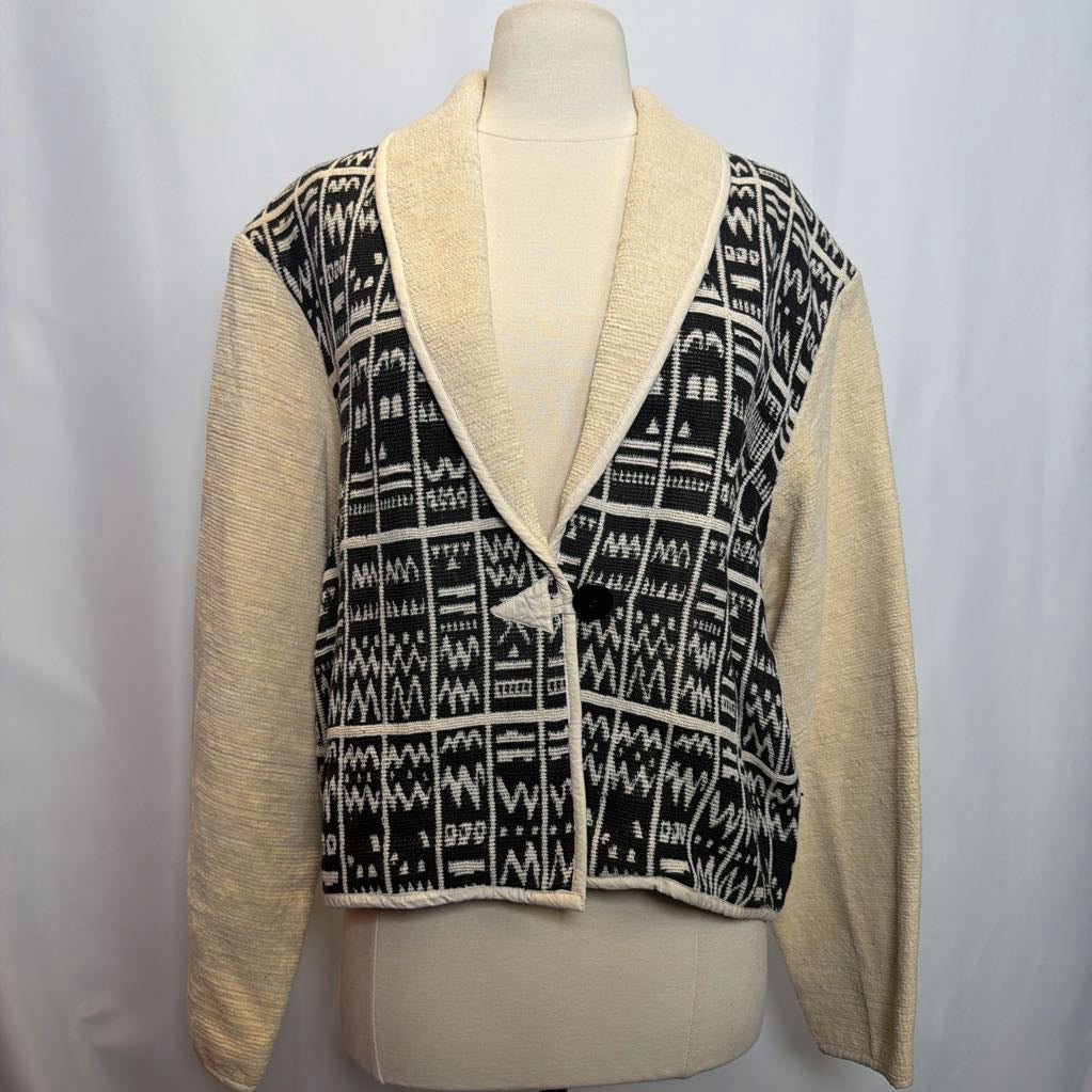 Mannequin wearing a beige cardigan with black and white patterned front panel on a plain background