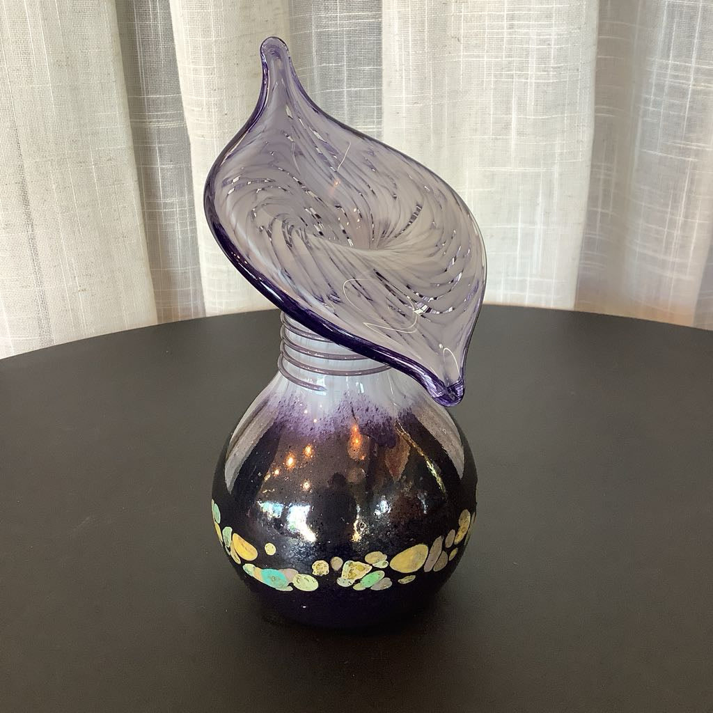 Glass vase with a unique design on a dark surface with a light curtain background