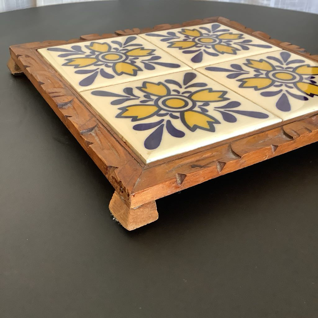 Decorative tray with ceramic tiles featuring floral patterns on a dark surface