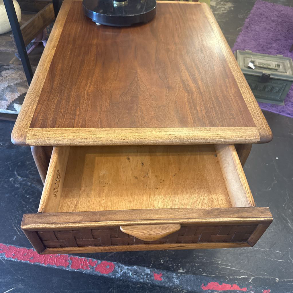Wooden side table with a drawer open on a dark surface