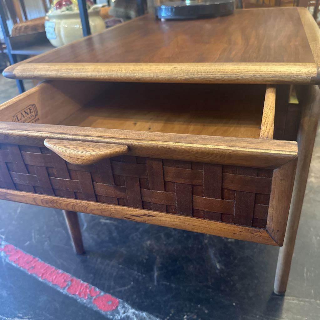 Wooden side table with woven design on a dark surface