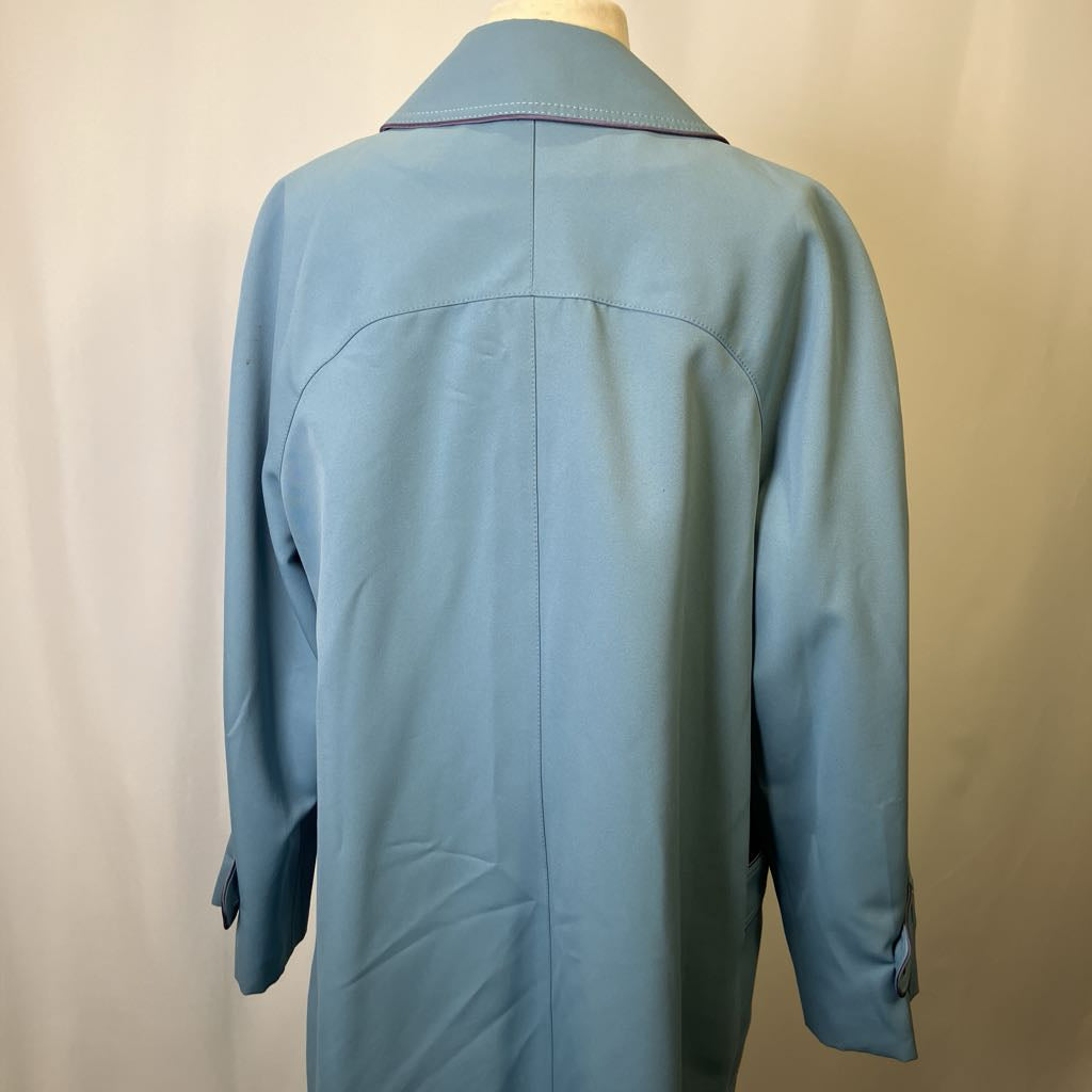 Blue coat on a mannequin against a beige background