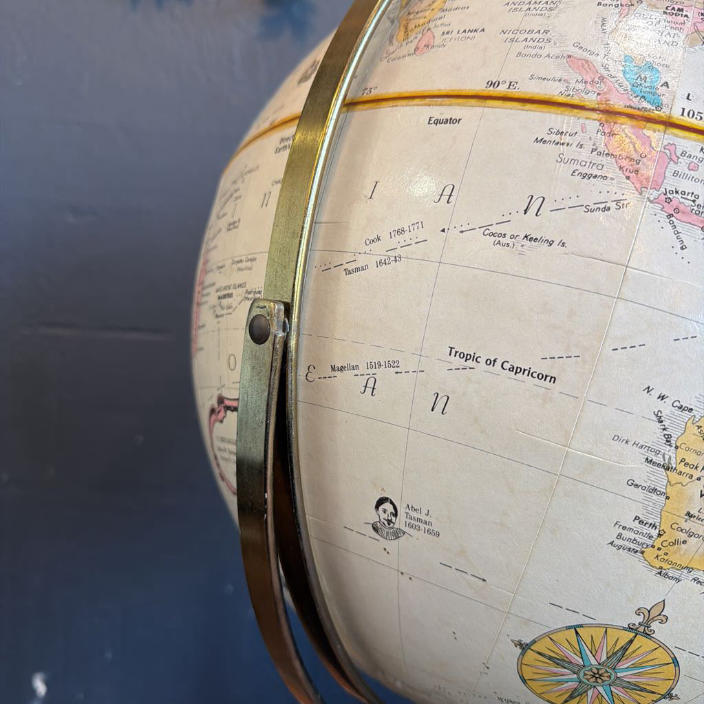 Close-up of a vintage globe with detailed world map on a blue background