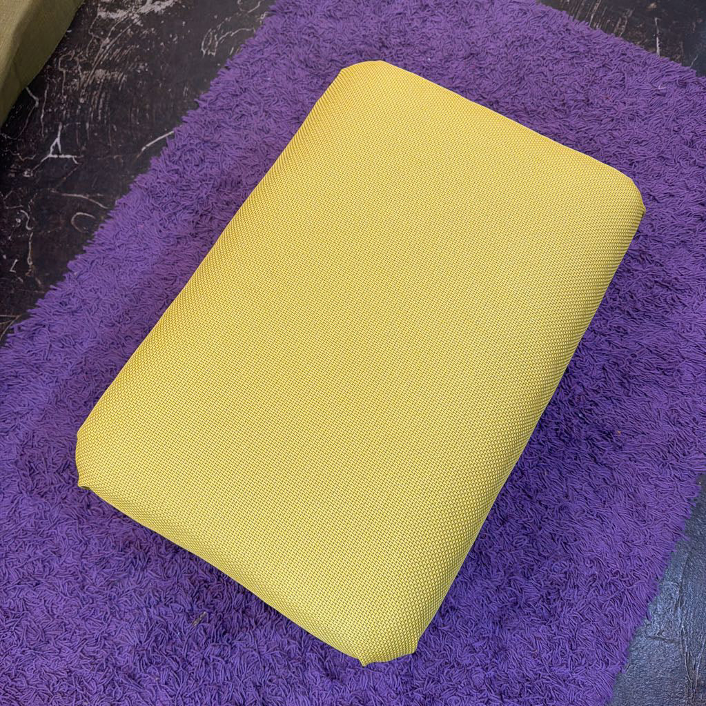 Yellow rectangular object on a purple textured surface