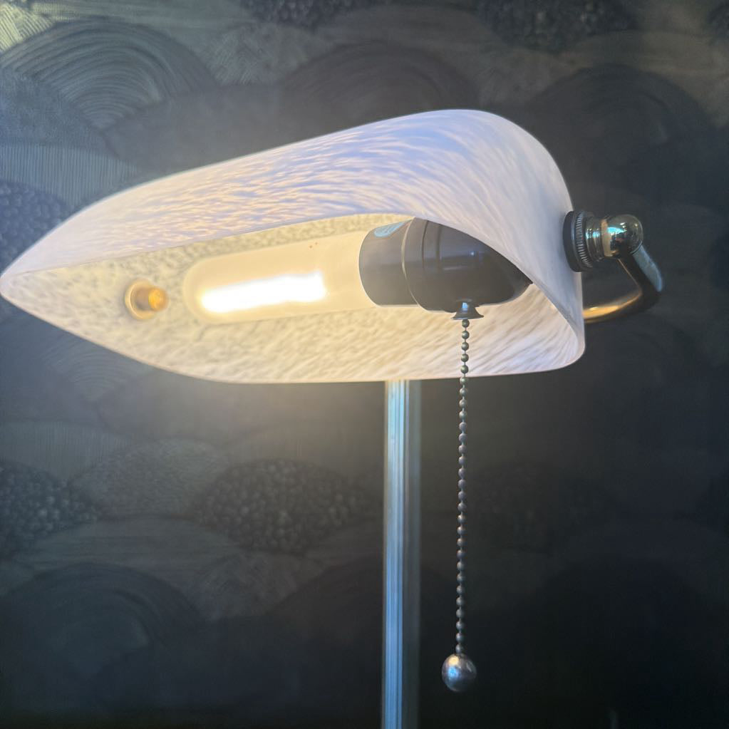 Floor lamp with textured shade and visible bulb against a dark background
