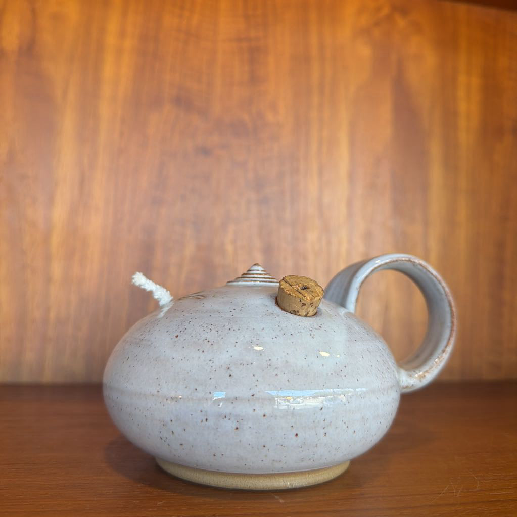 Ceramic teapot with wooden lid on a wooden surface and background