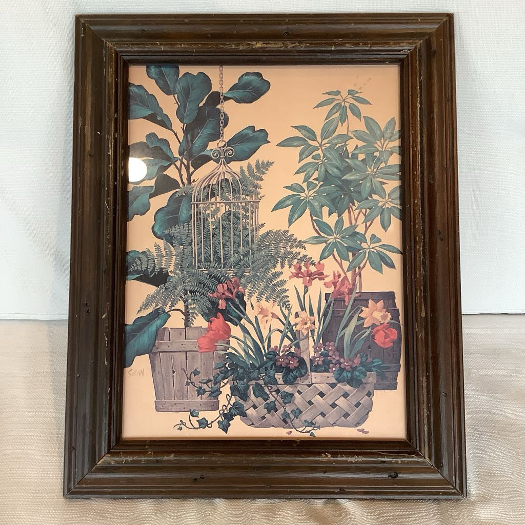 Framed artwork with plants and a birdcage on a beige background