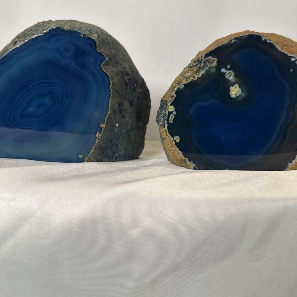 Two agate stones with blue interior on a white fabric background
