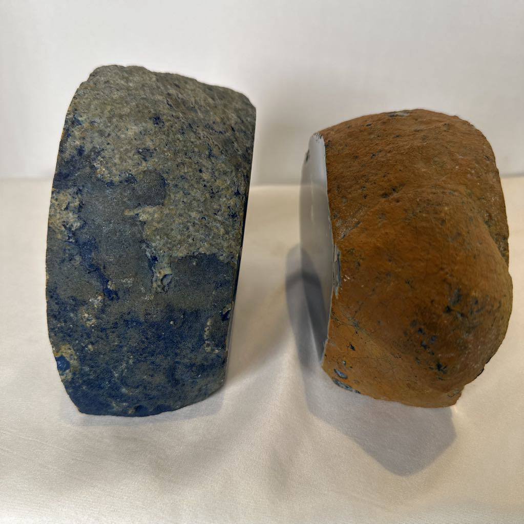 Two rocks, one blue and one brown, on a white background