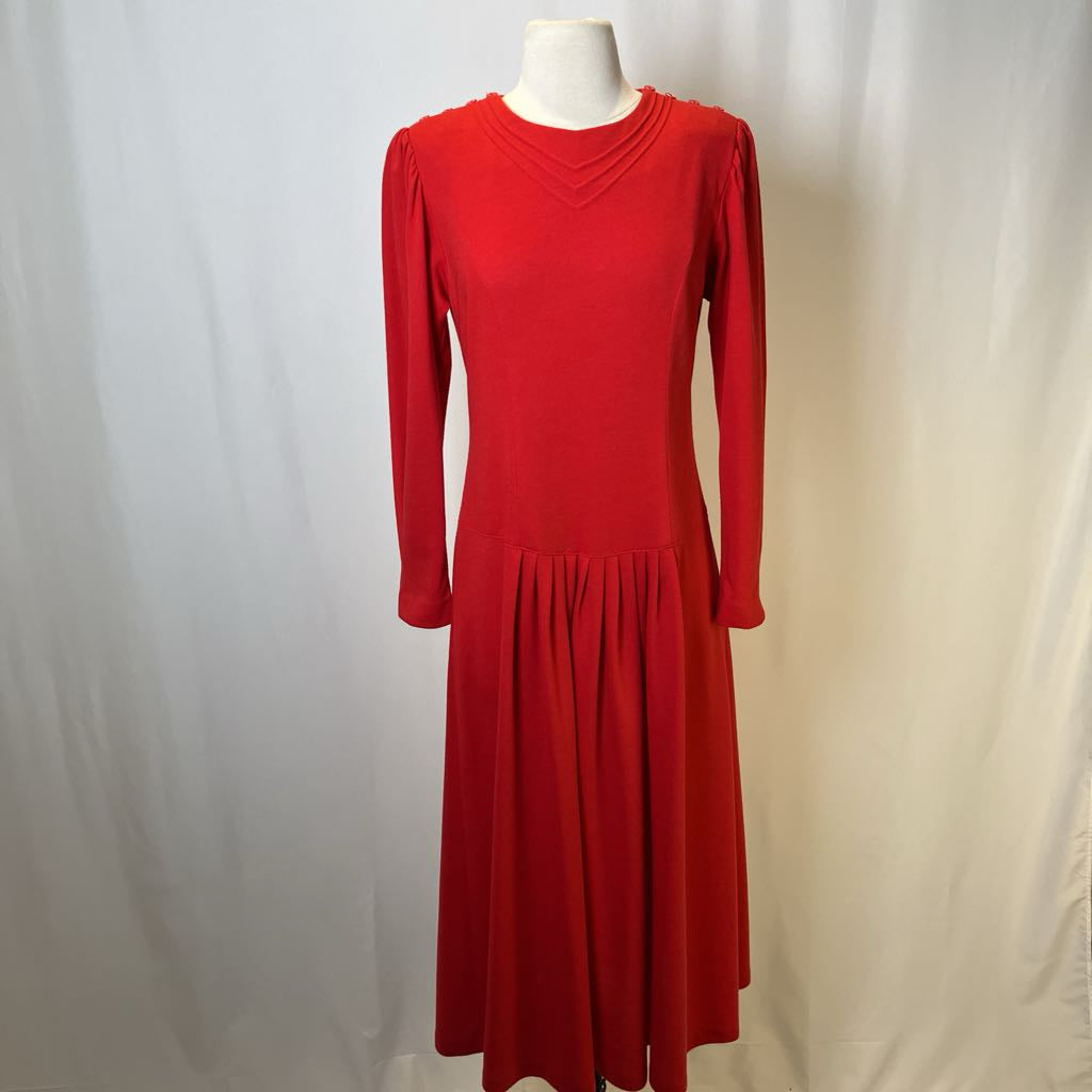 Red dress on a mannequin against a plain background