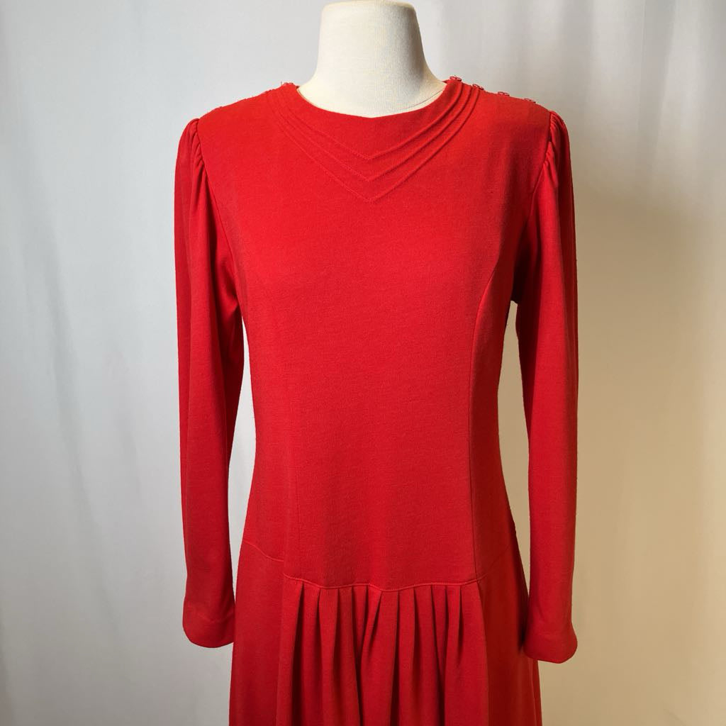 Red dress on a mannequin against a plain background