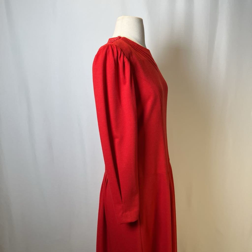 Red dress on a mannequin against a plain background