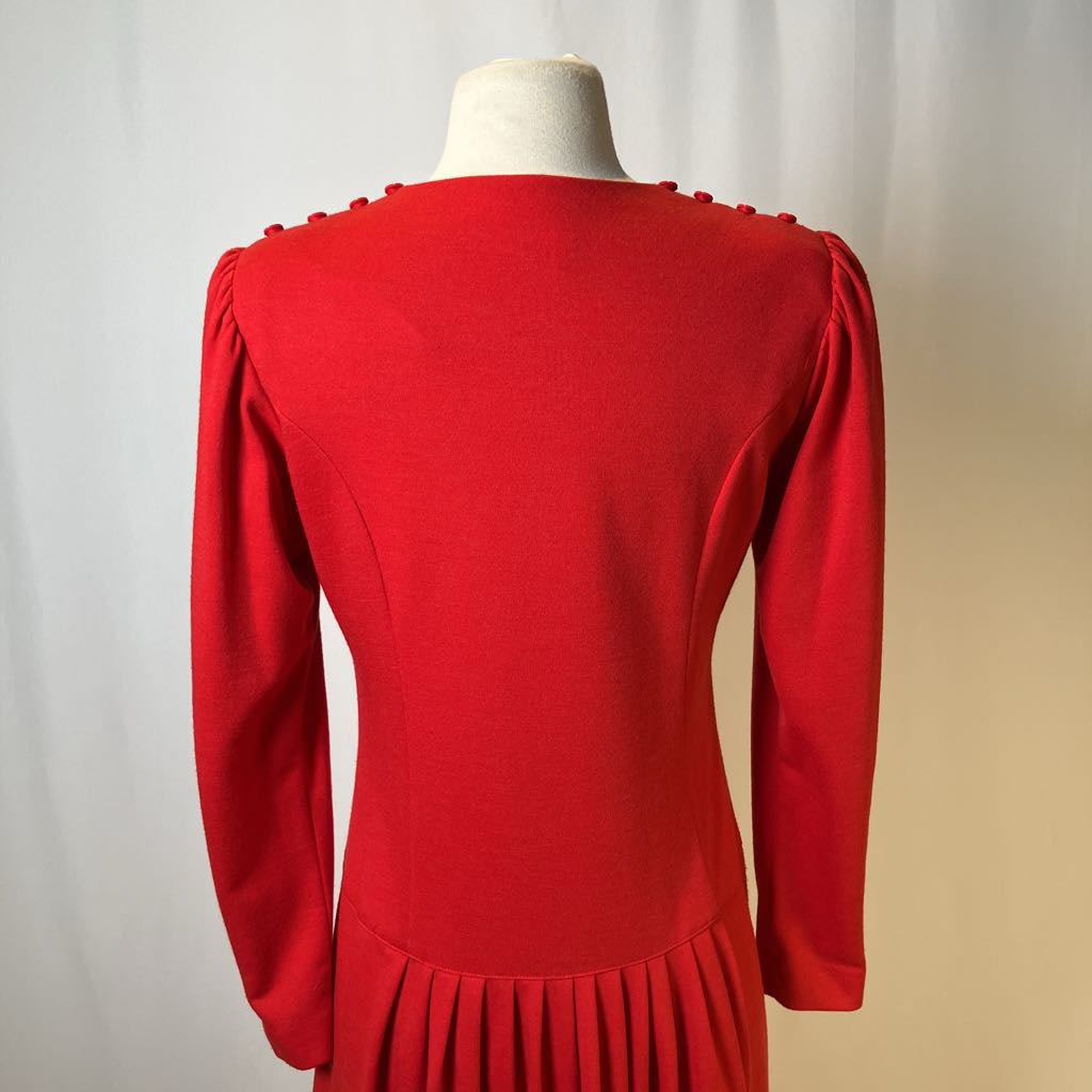 Red dress on a mannequin against a plain background