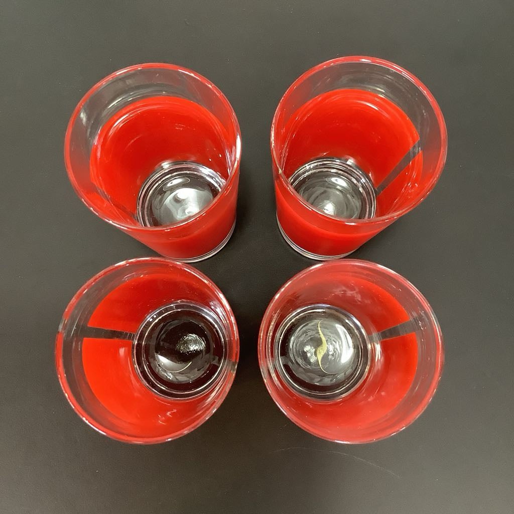 Four red glasses on a gray background