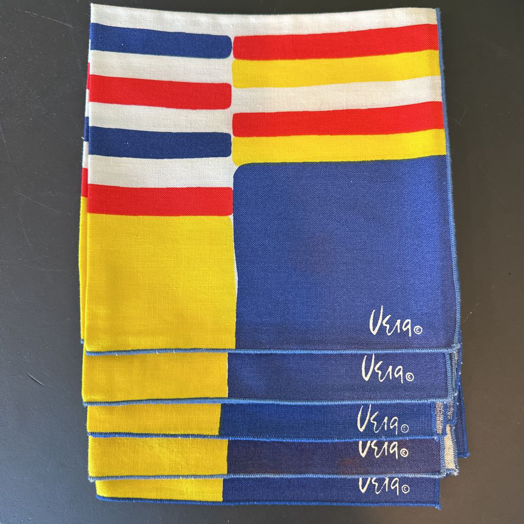 Folded fabric with red, yellow, and blue stripes on a dark background