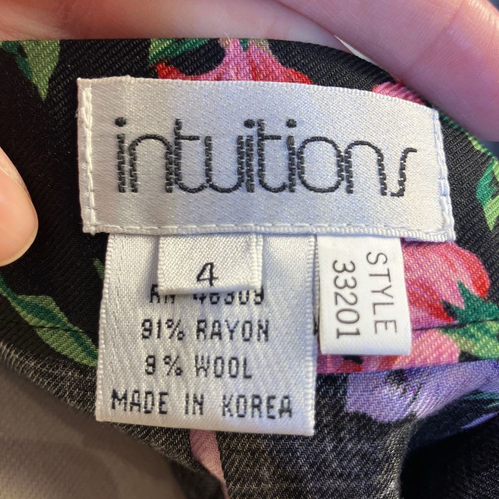Clothing label with 'intuitions' brand on a floral fabric background