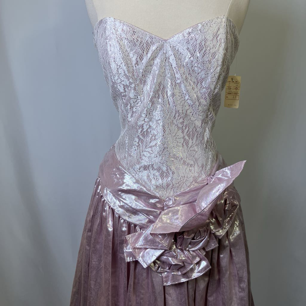 Mannequin wearing a silver lace top and pink velvet skirt with floral details against a plain background