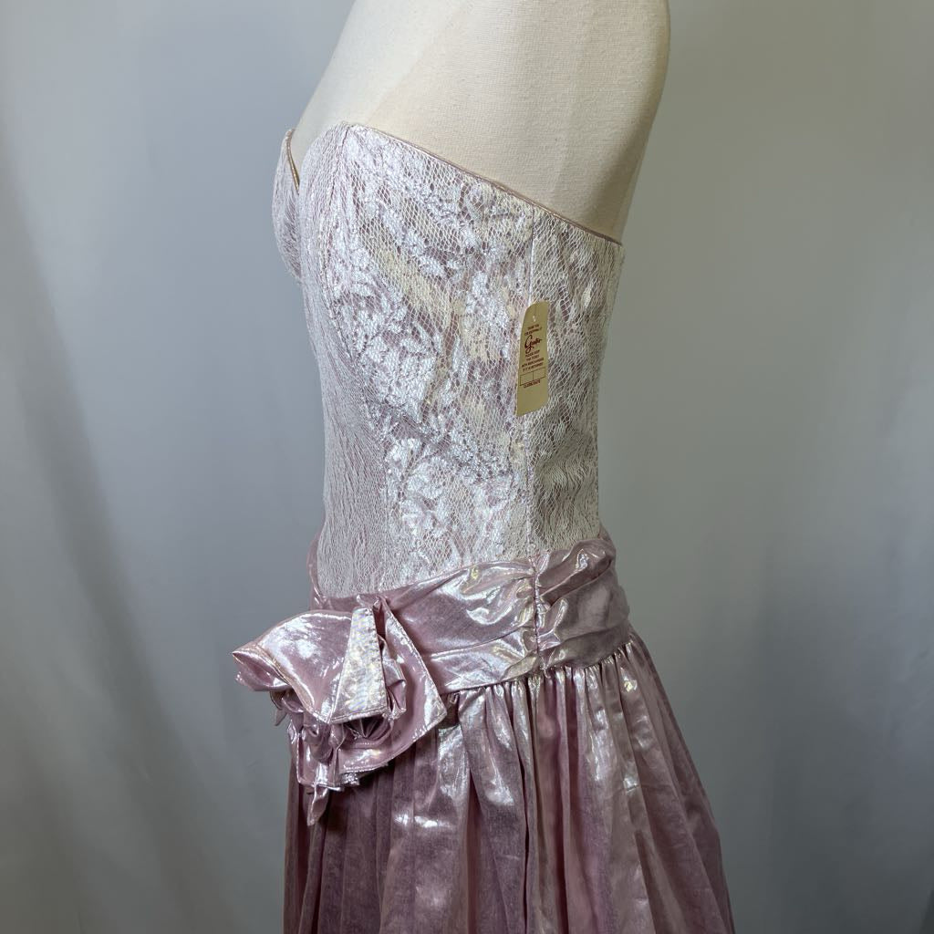 Mannequin wearing a pink lace top and skirt with a plain background