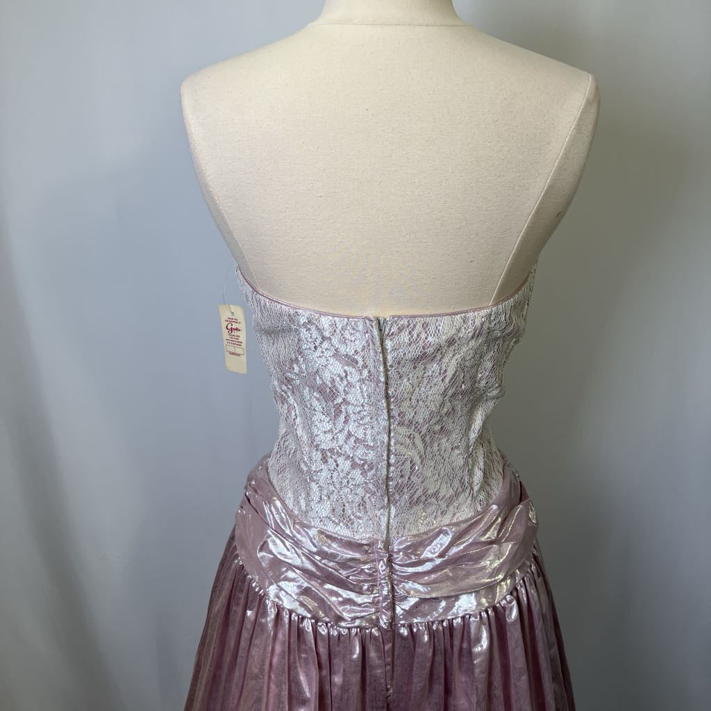 Mannequin wearing a pink lace dress with a visible tag on a plain background