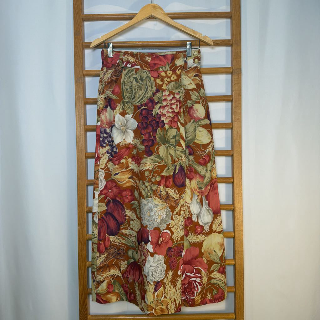 Floral patterned skirt on a wooden hanger against a white background