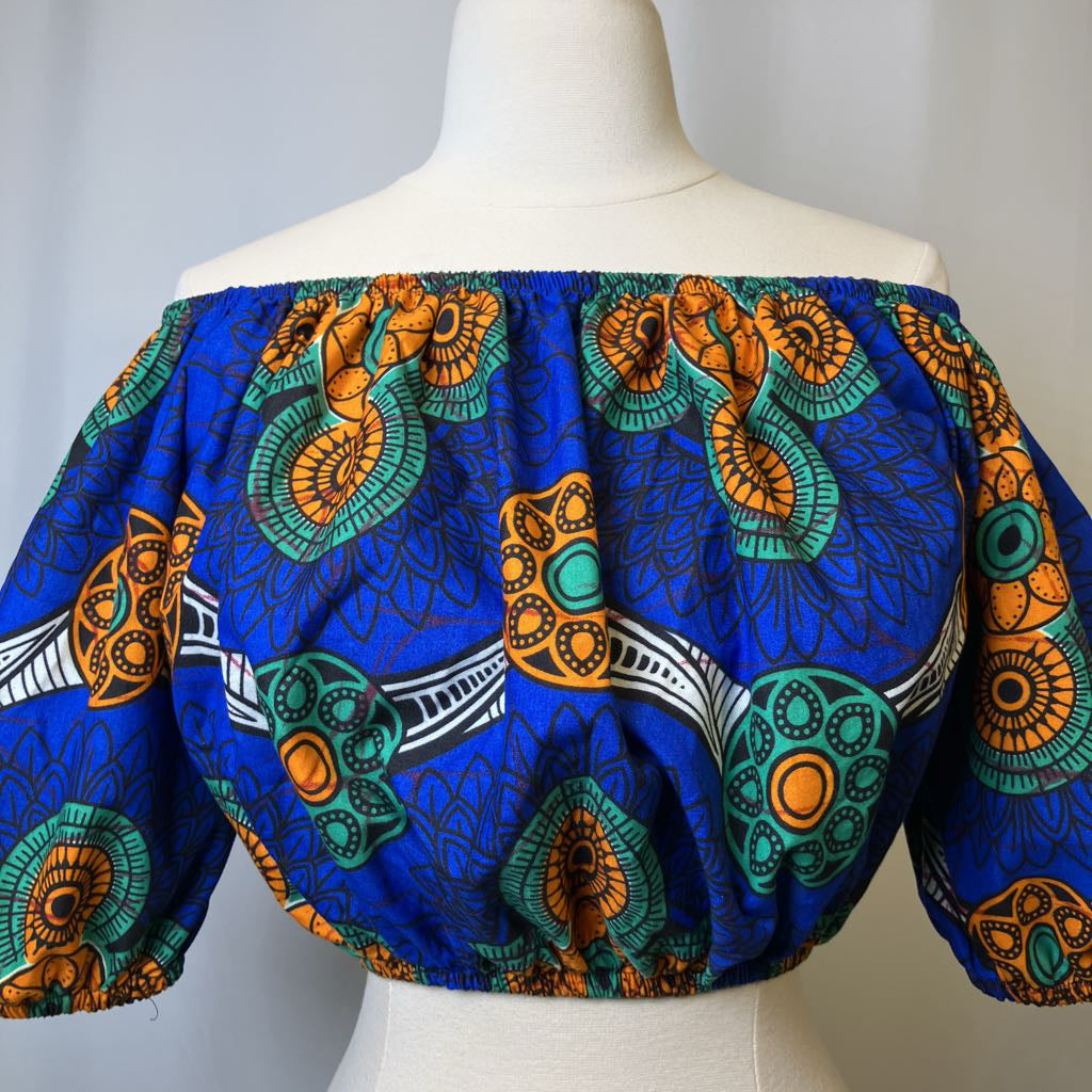 Colorful off-shoulder top with African print design on a mannequin against a plain background